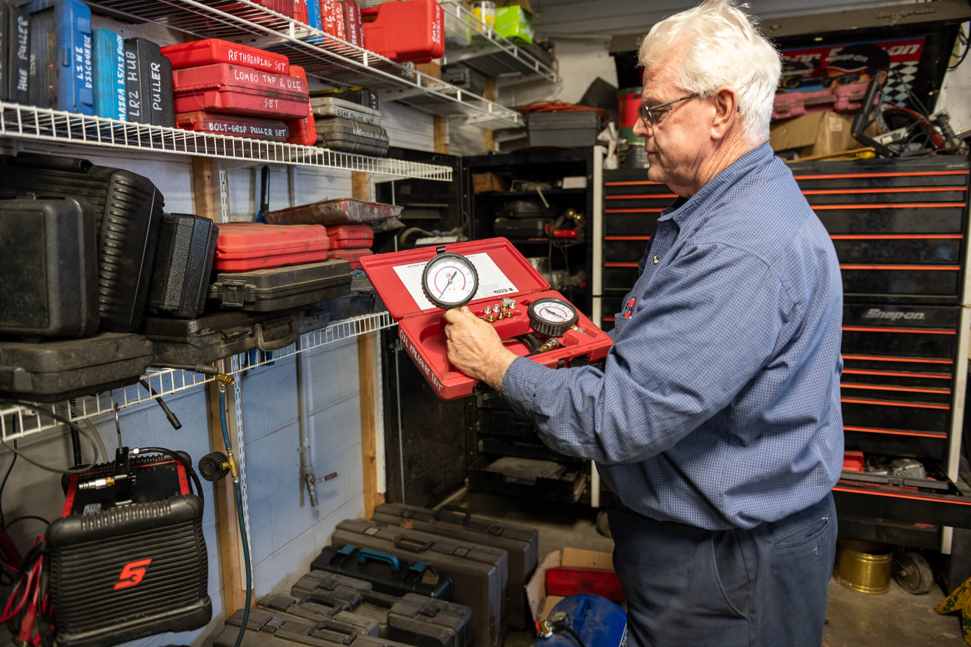 A man holding a red box with a gauge.