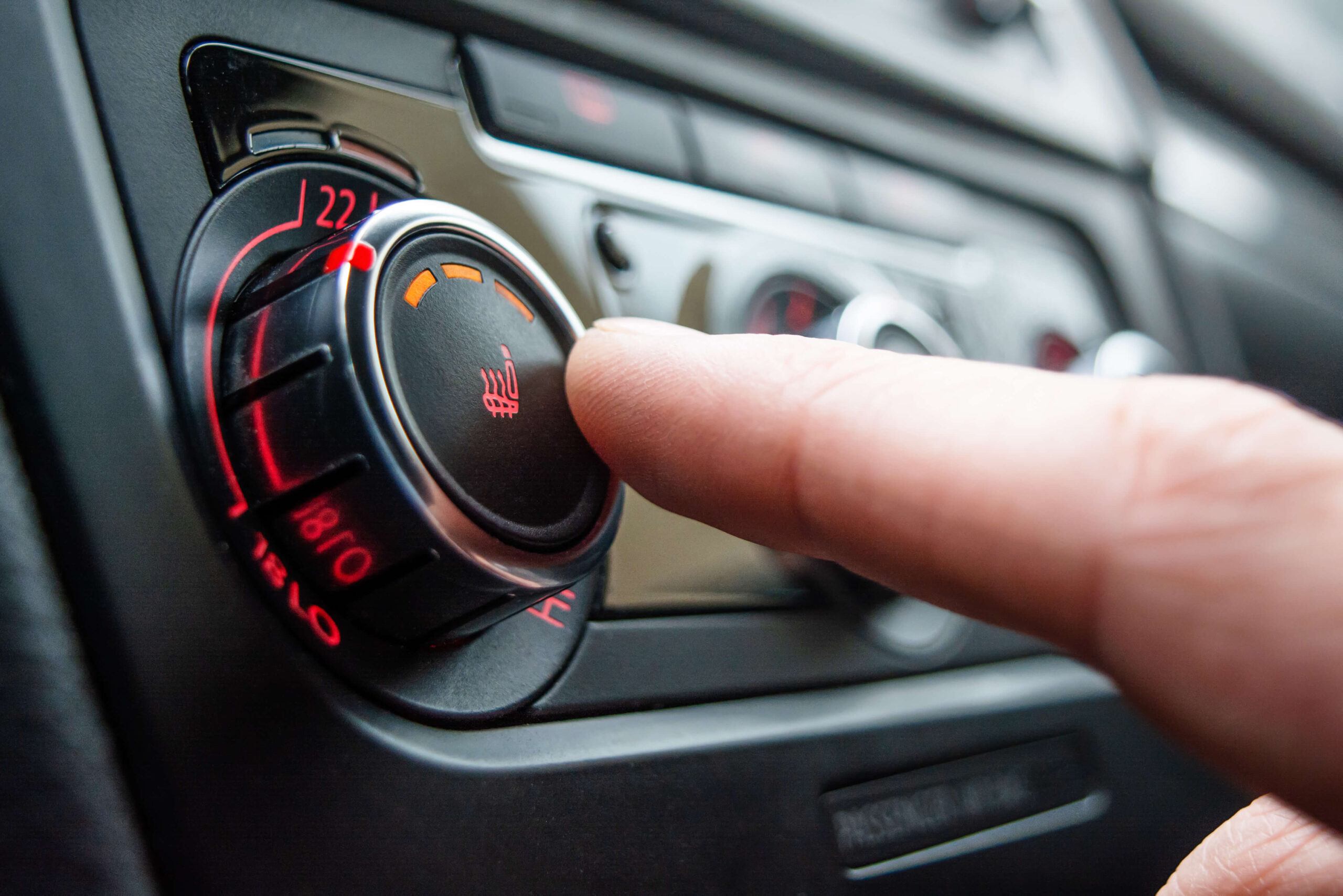 A person pressing a button in a car.