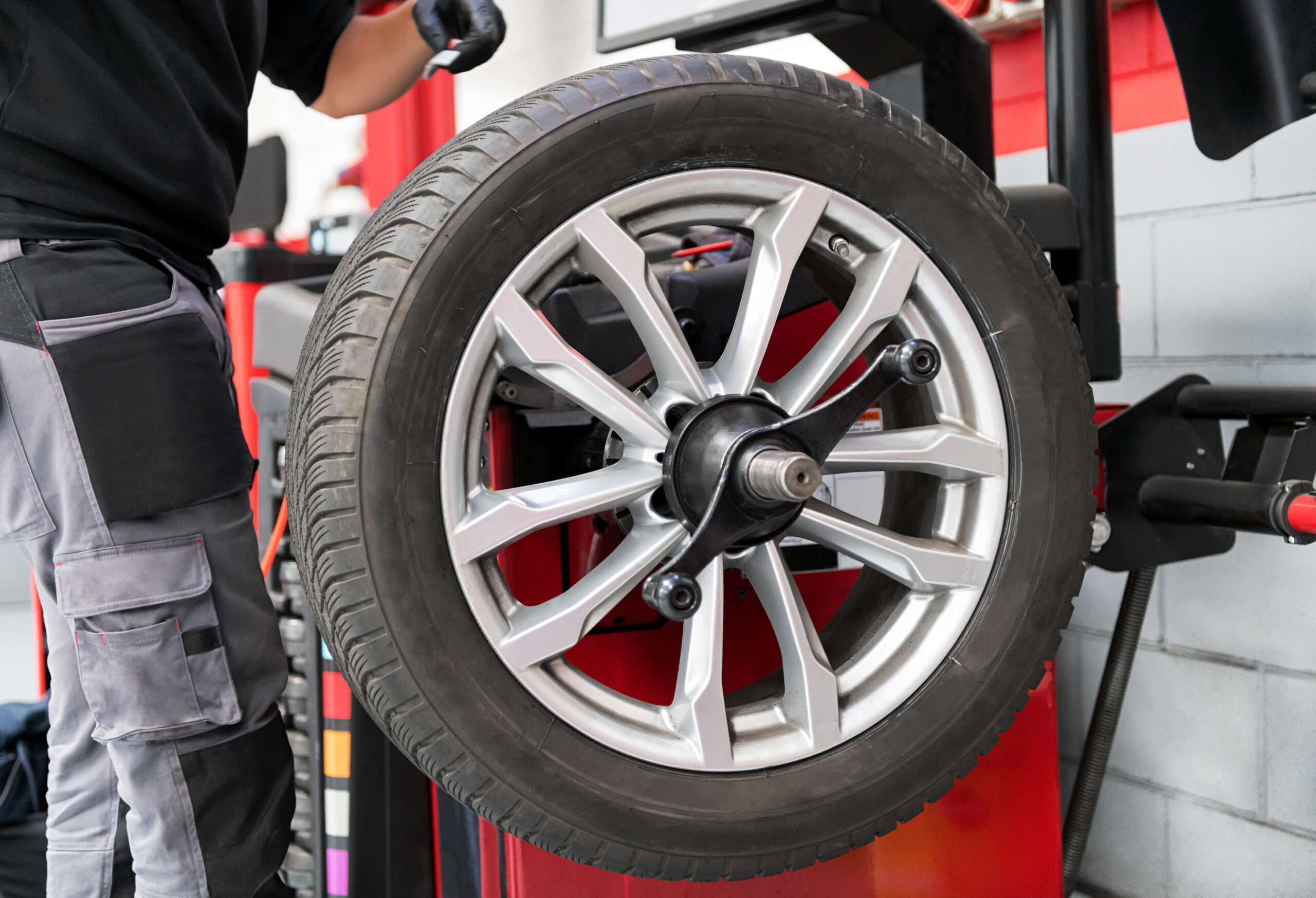 A mechanic is working on a tire in a garage.