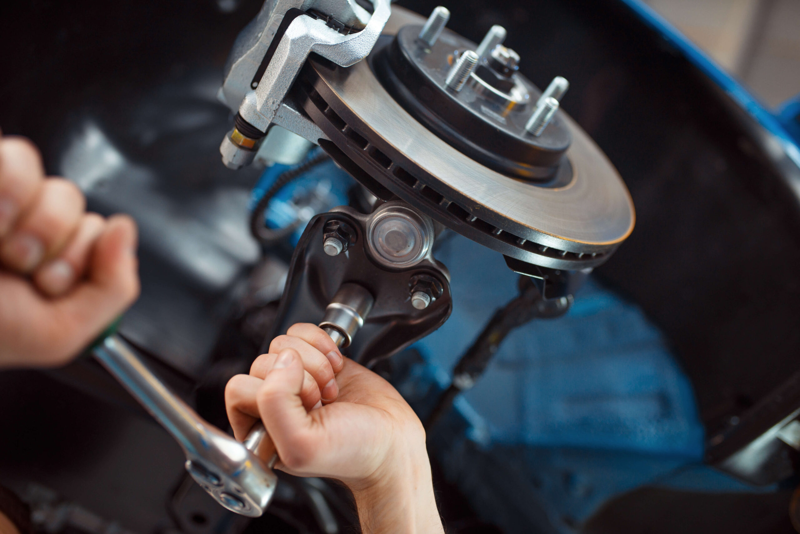 A person is working on a car's brakes.